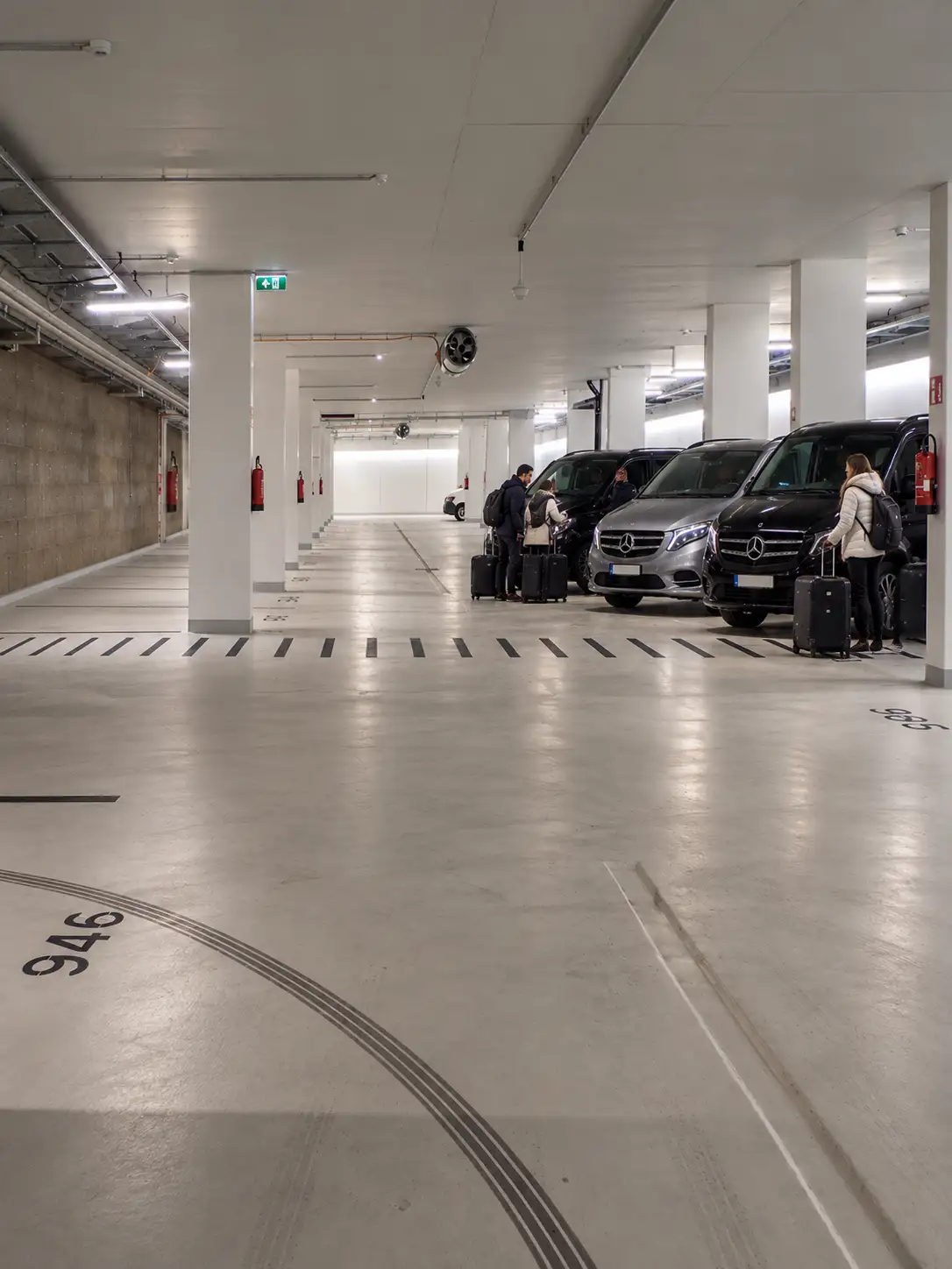 Vehicles and guests with cases in the underground garage beneath the Oberlechbahn valley station in Lech
