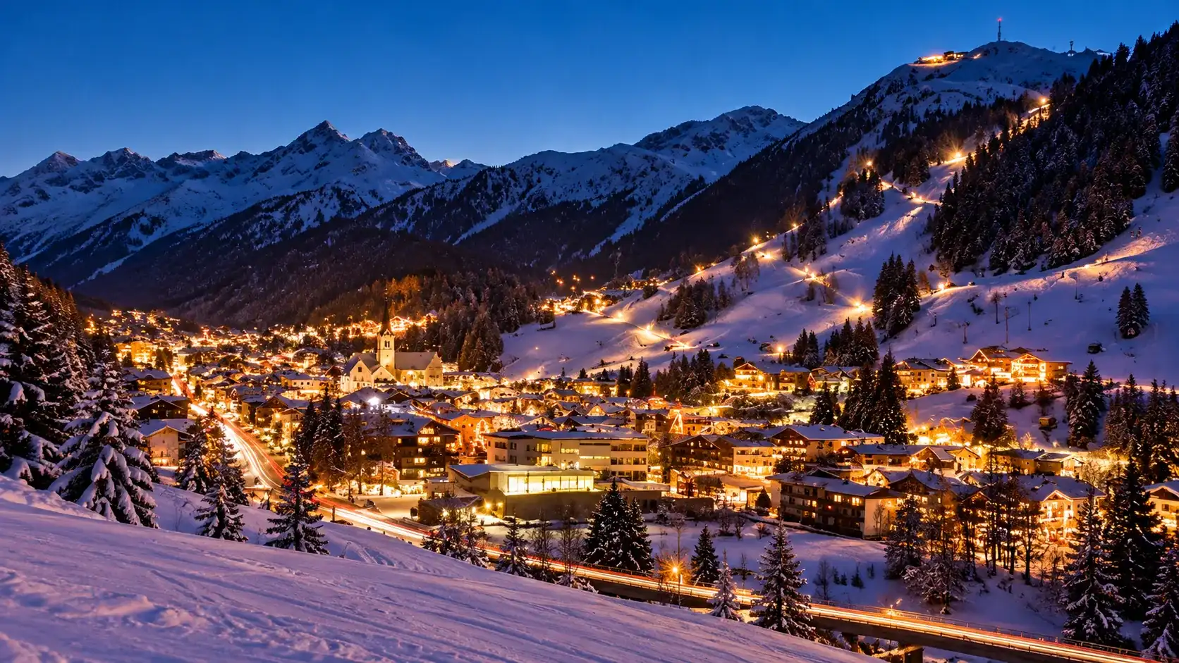 Munich Airport to St. Anton am Arlberg St. Anton am Arlberg at dusk: the lit village in the valley with the snow-covered slopes above