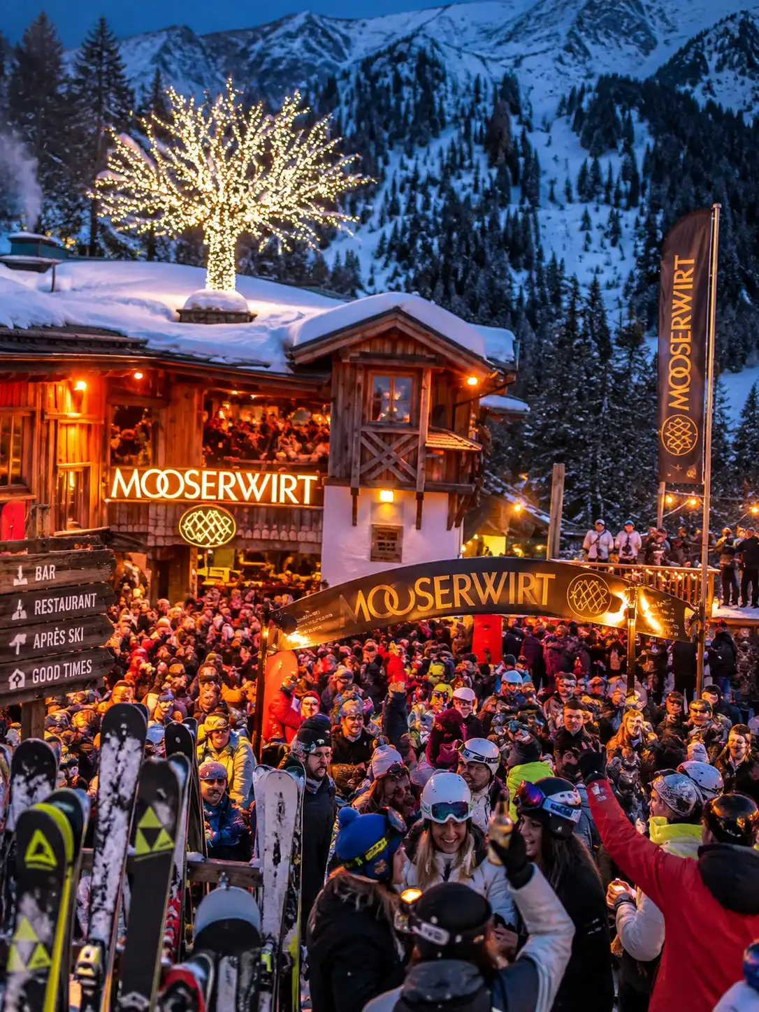 Après-ski at the Mooserwirt above St. Anton am Arlberg Crowds outside the Mooserwirt après-ski bar above St. Anton am Arlberg at dusk, with skis stacked in the snow